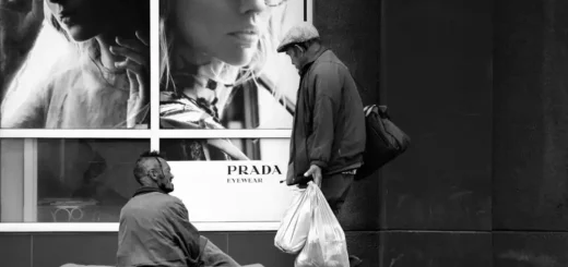 Un homeless davanti la vetrina di Prada, simbolo crisi di valori sociali
